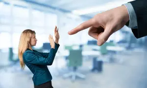 Kobieta broni się przed wskazującym palcem szefa. Czy pracodawca może odmówić urlopu na żądanie?