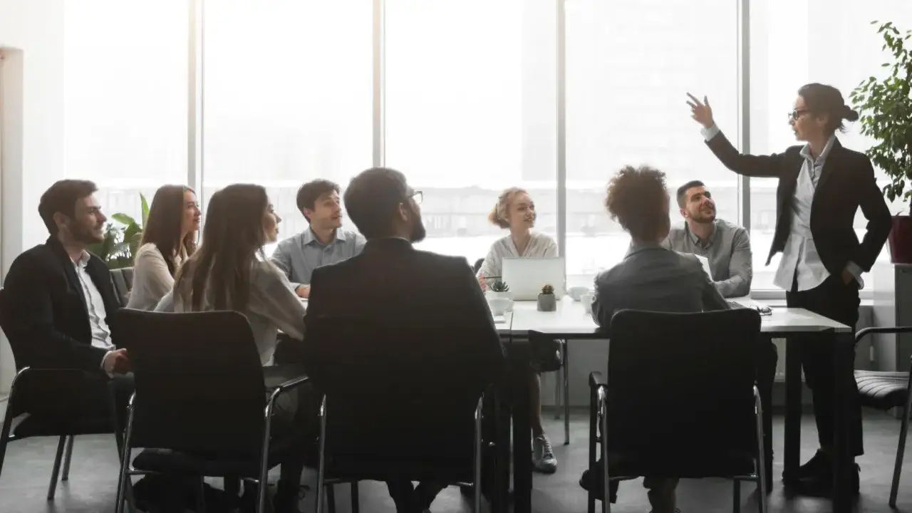 Kobieta w garniturze prowadzi prezentację dla zespołu. Skuteczne networking w biznesie.