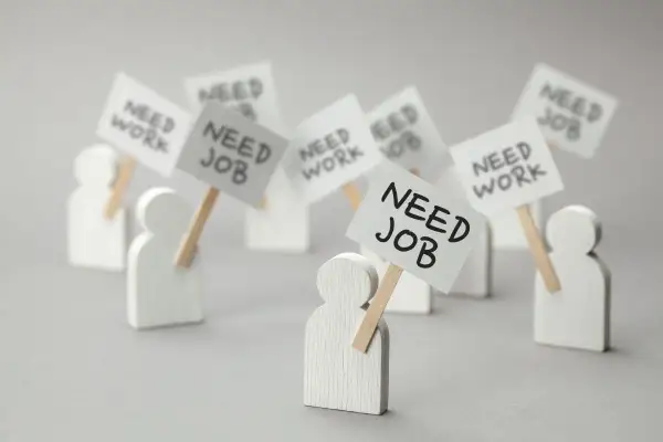 Figurki ludzi z transparentami "NEED JOB" i "NEED WORK". Dowiedz się, jak sprawdzić status bezrobotnego online.